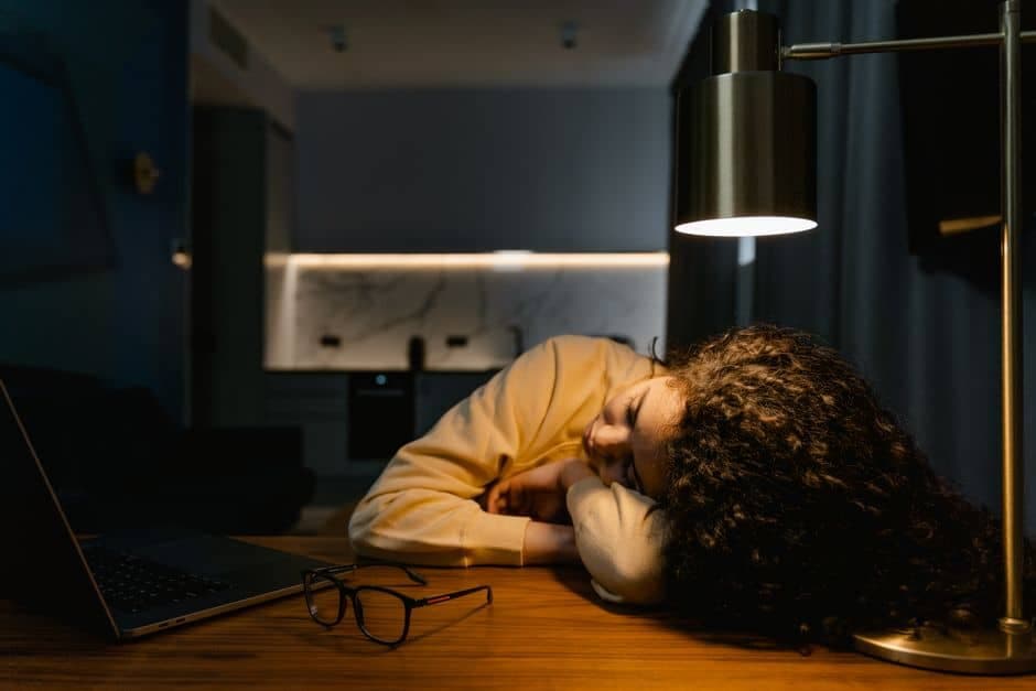Homem cansado debruçado sobre a mesa de trabalho