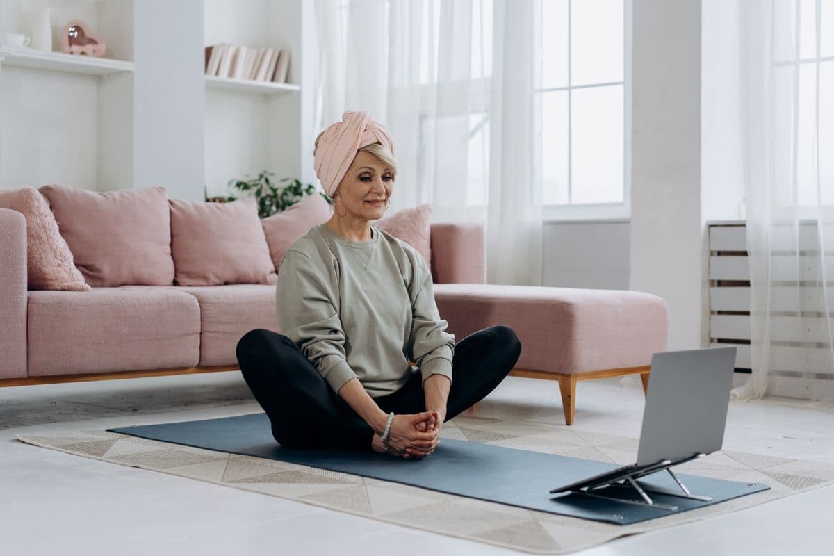 Pessoa usando um aplicativo de meditação ao lado do laptop em um home office