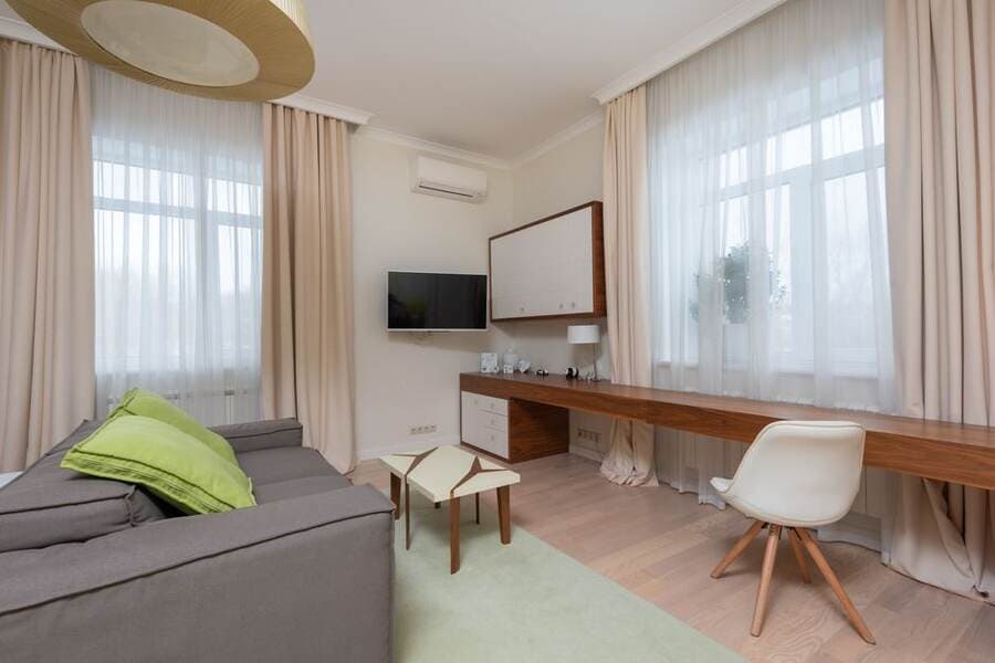 Janela com cortinas em uma sala de apartamento com mesa de trabalho Janela com cortinas em uma sala de apartamento com mesa de trabalho