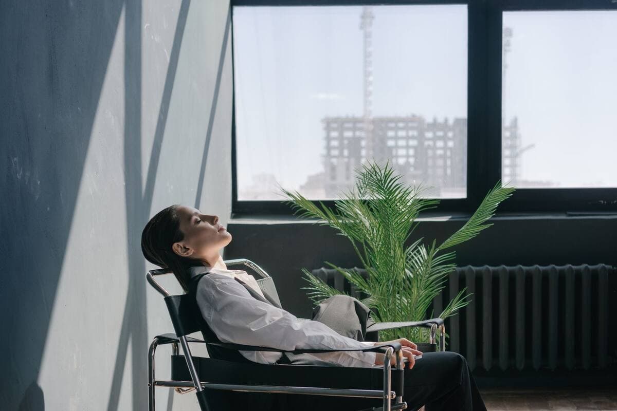 Mulher descansando a vista perto da janela no escritório