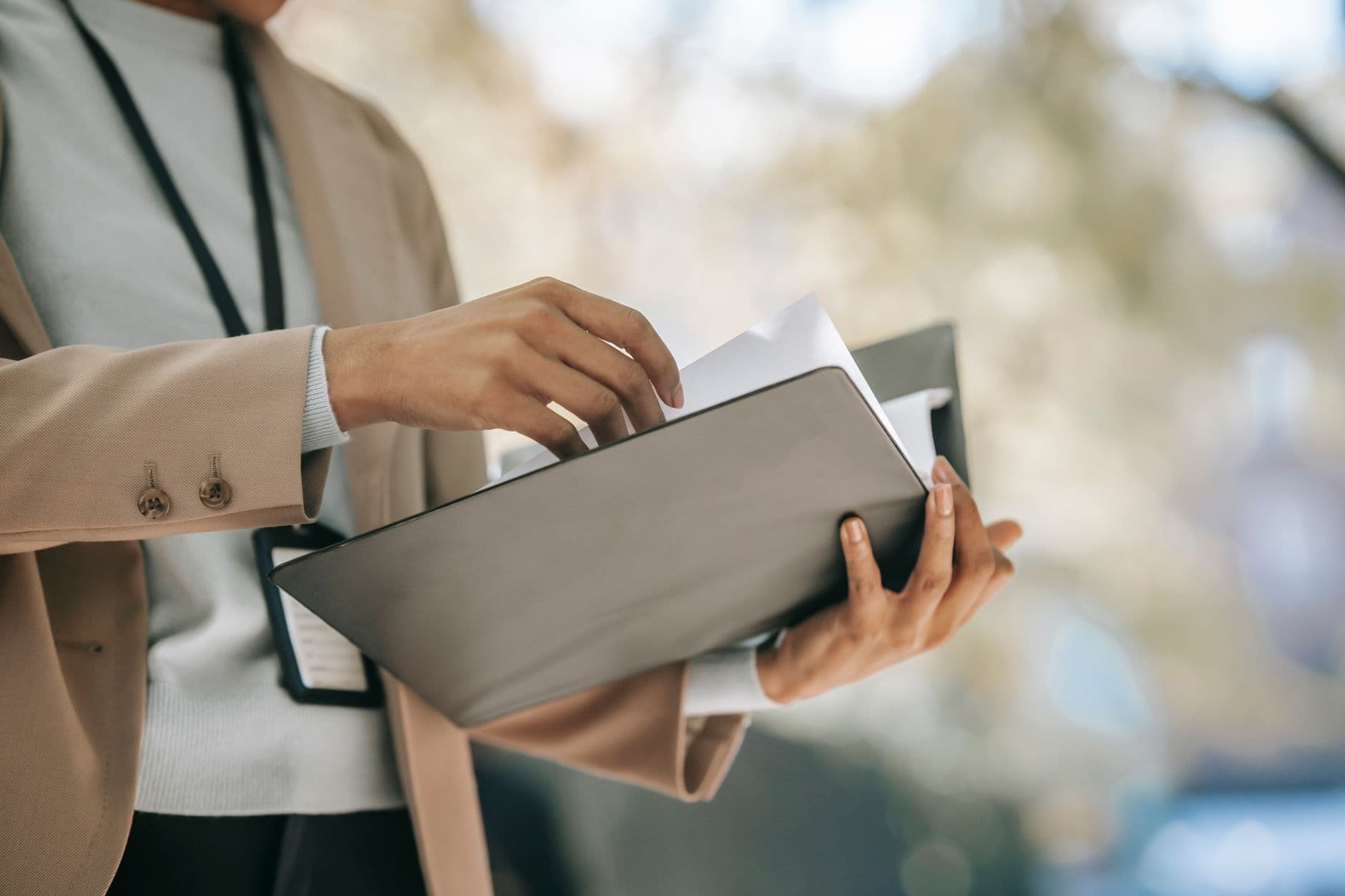 Cliente não paga: o que fazer como freelancer remoto Crop anonymous female entrepreneur in elegant jacket with badge looking through papers in folder