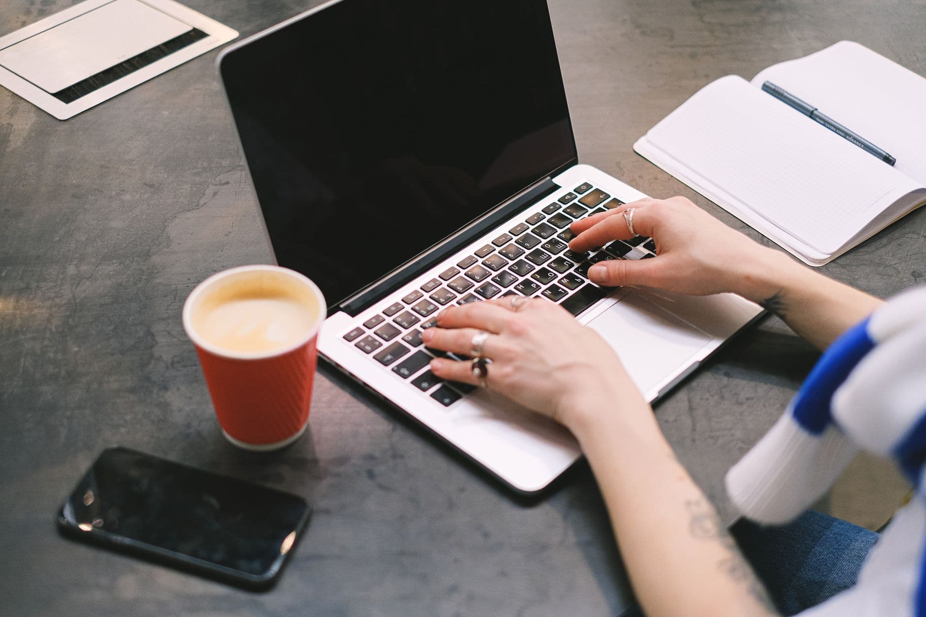 Freelancer trabalhando em um laptop em uma mesa organizada de home office.