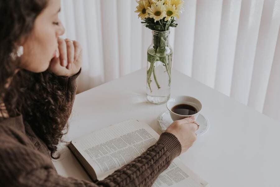 Mulher digitando no notebook com foco e uma xícara de café ao lado Mulher digitando no notebook com foco e uma xícara de café ao lado