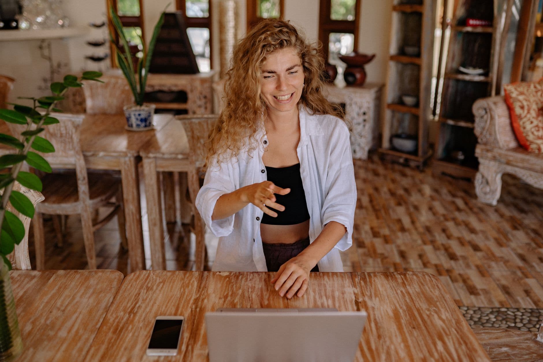Como diversificar clientes sendo freelancer Happy woman working remotely with laptop in a cozy home environment.