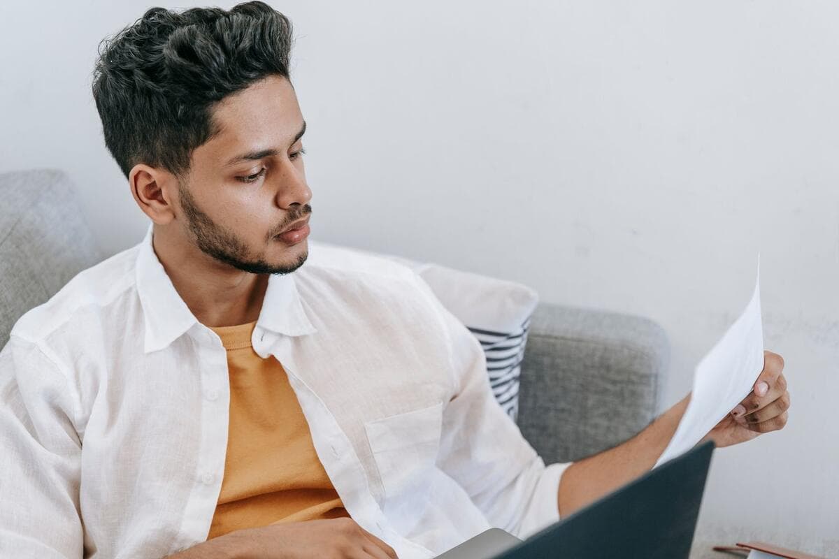 Quando sair do chat Homem concentrado lendo mensagem no notebook enquanto trabalha no sofá