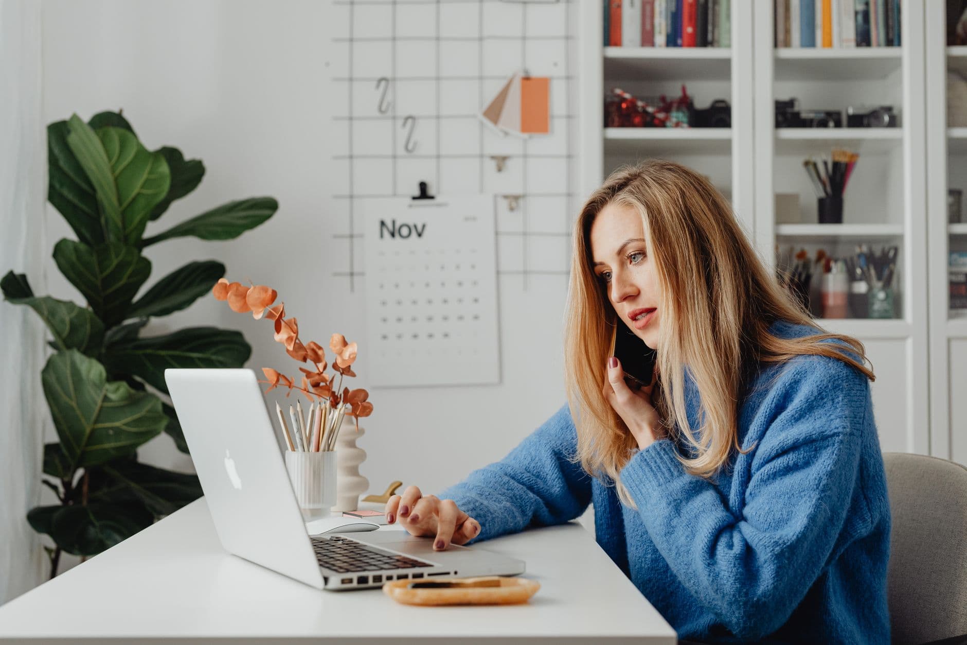 Profissional trabalhando no laptop em casa enquanto organiza a agenda de reuniões
