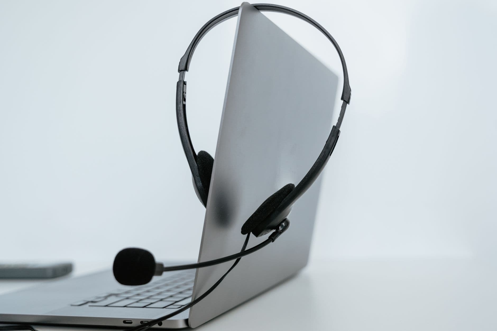 Como funciona a videoconferência no trabalho remoto Close-up of a laptop with a headset, symbolizing remote work or online communication.