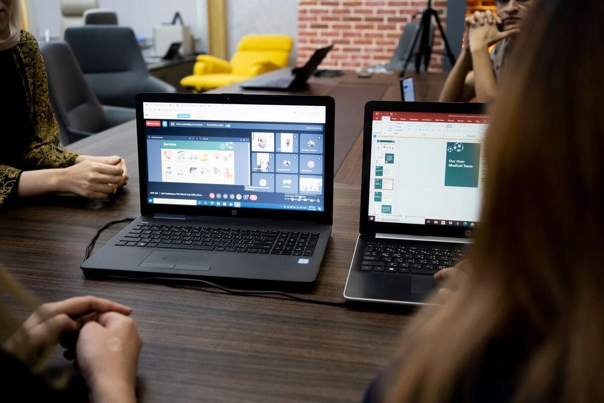 Equipe em reunião com notebooks mostrando uma videochamada