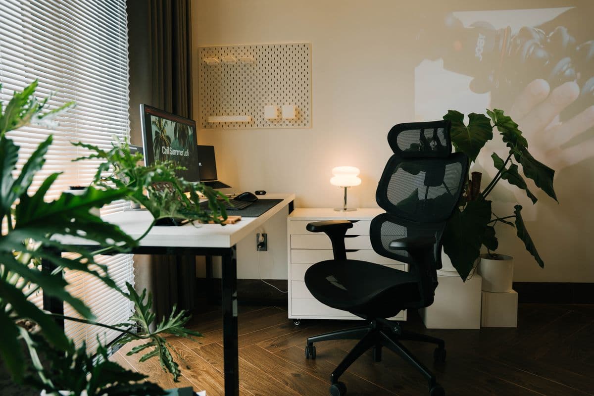 Pessoa trabalhando no notebook em uma mesa de home office e ajustando a postura