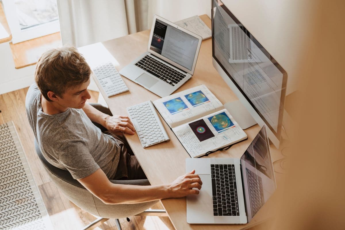 Estudante trabalha em casa com notebook durante uma atividade de estágio remoto.