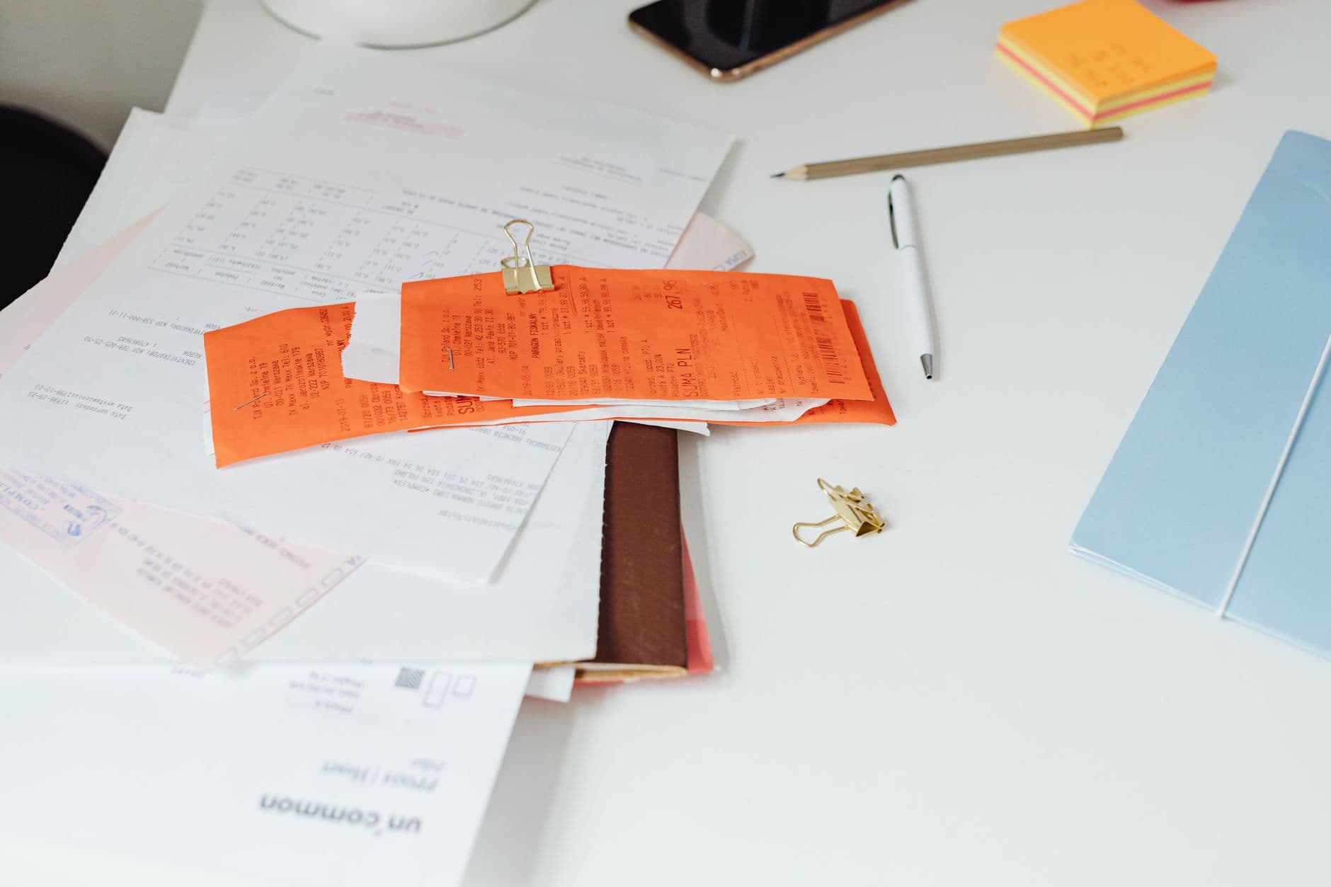 Ferramentas de gestão financeira para freelancer Close-up of a tidy desk with receipts, documents, and office stationery for business organization.