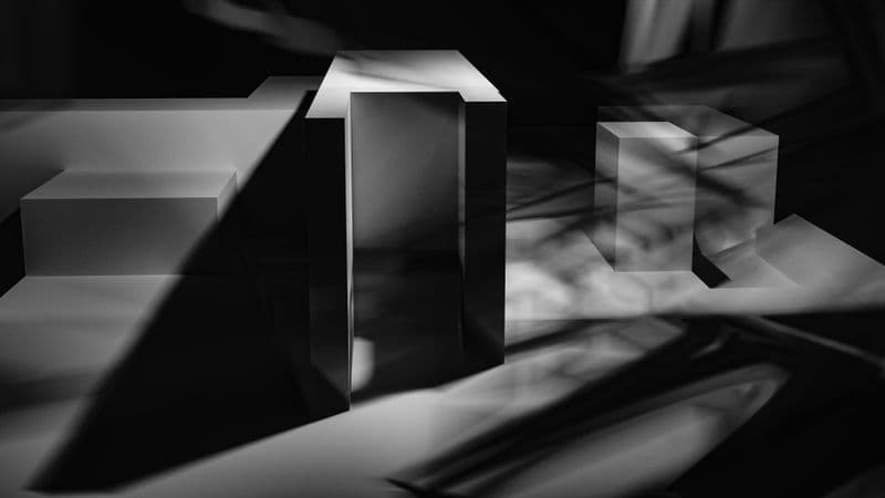 Freelancer de modelagem 3D: como começar Monochrome abstract geometric art with shadows and light play, featuring 3D shapes.