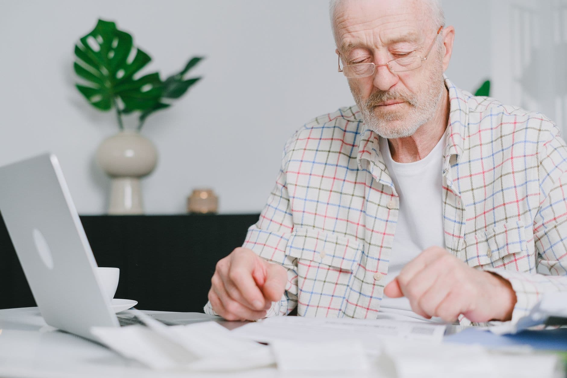 Freelancer conferindo uma invoice em um notebook sobre a mesa de trabalho