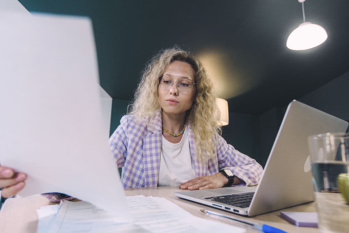 Freelancer analisando uma proposta de projeto em um laptop sobre a mesa de trabalho