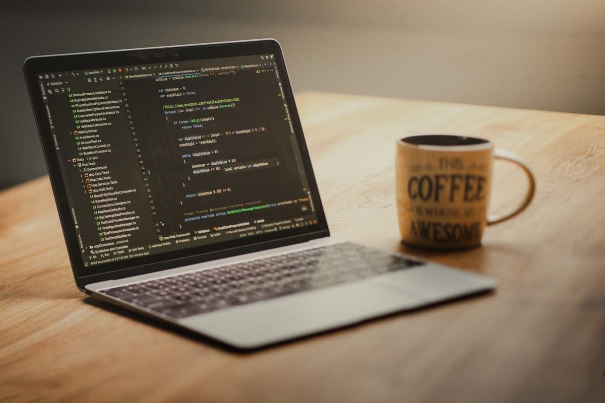 Programador trabalhando em um projeto freelance diante de um laptop em um home office