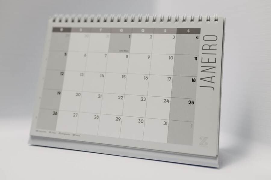 Agenda e calendário sobre a mesa para planejar horários e prazos Agenda e calendário sobre a mesa para planejar horários e prazos