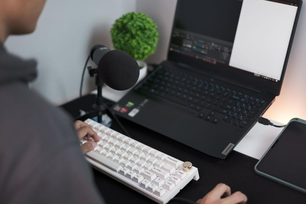Headset: quando é a melhor escolha Mesa de home office com notebook, microfone USB e teclado