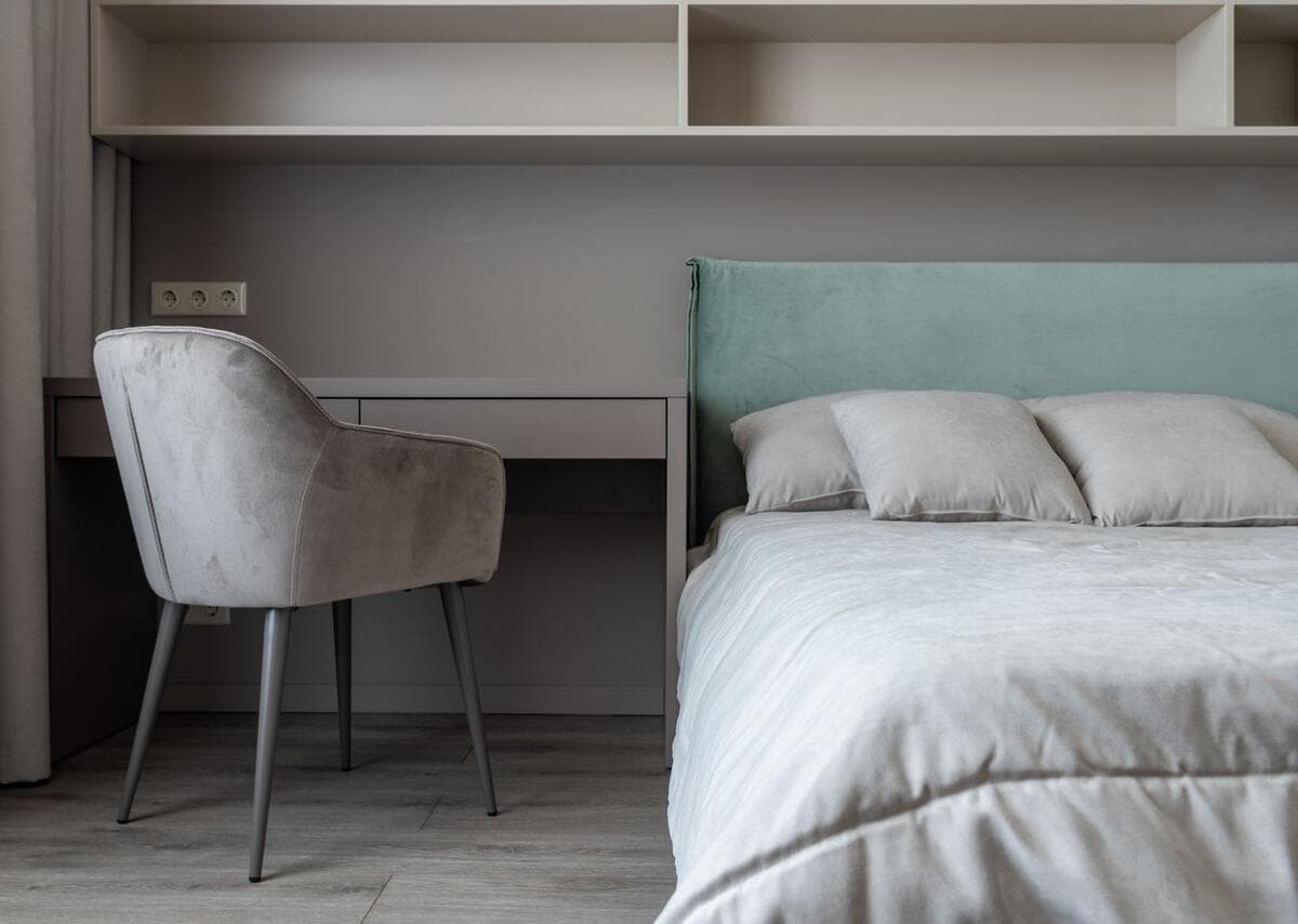 Quarto com mesa de trabalho e cadeira ao lado da cama