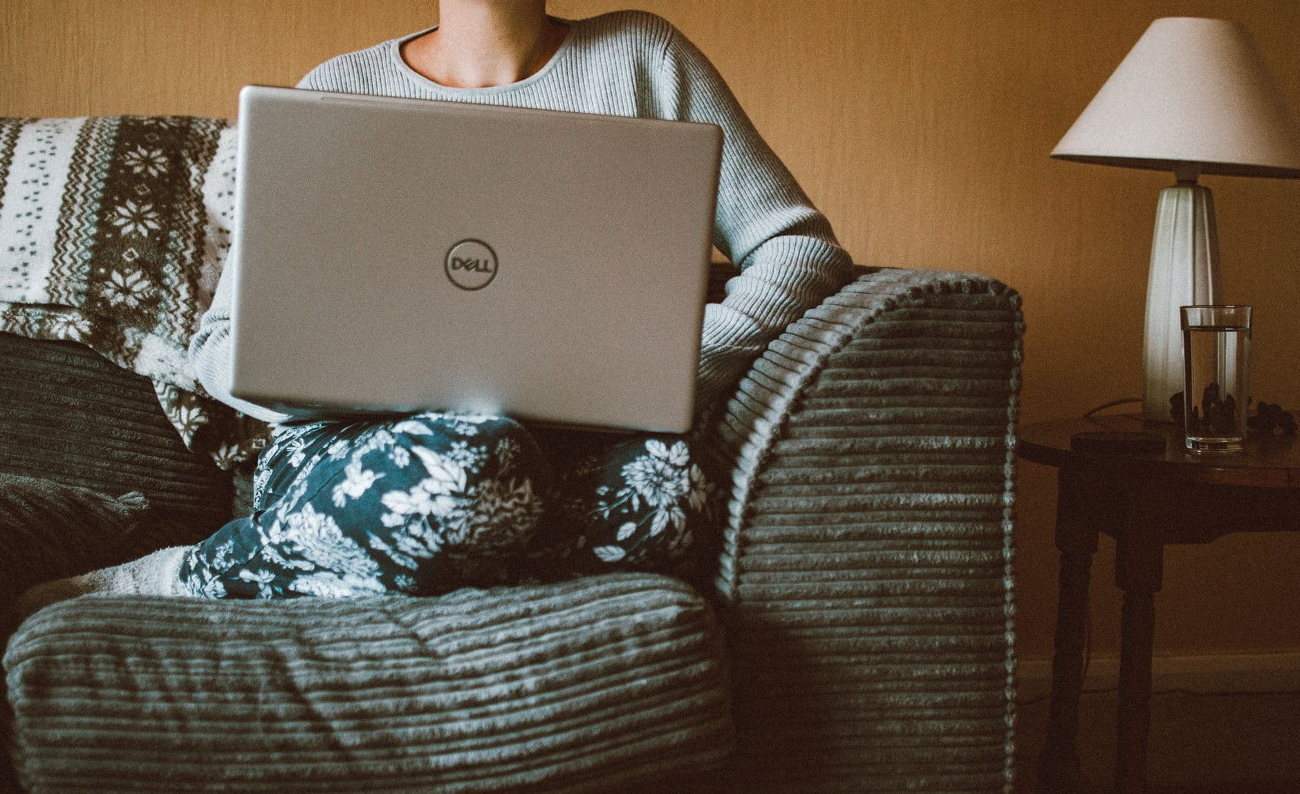 Pessoa trabalhando em casa com notebook conectado ao roteador durante uma reunião online