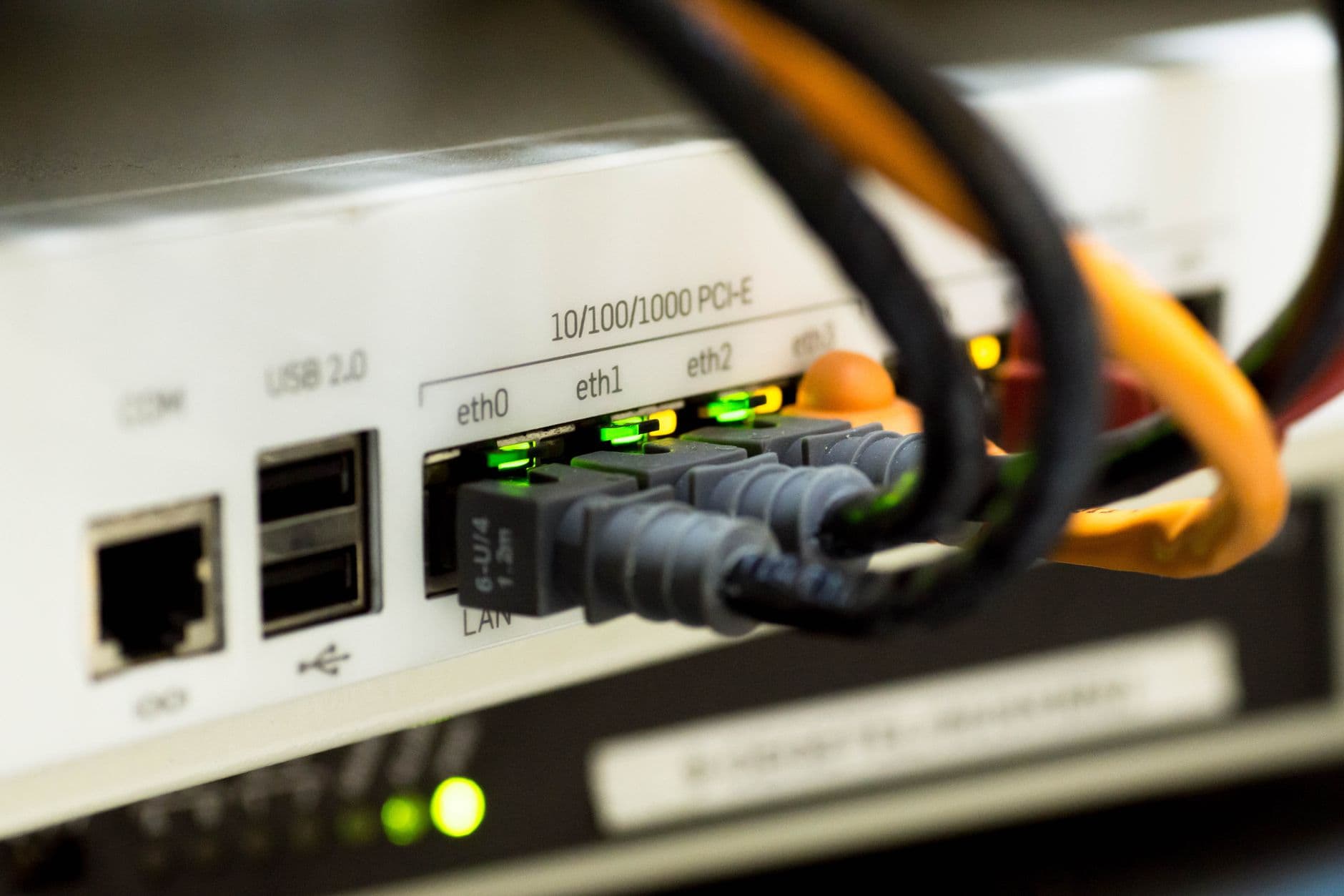 Qual internet é ideal para trabalho remoto Detailed close-up of ethernet cables and network connections on a router, showcasing modern technology.