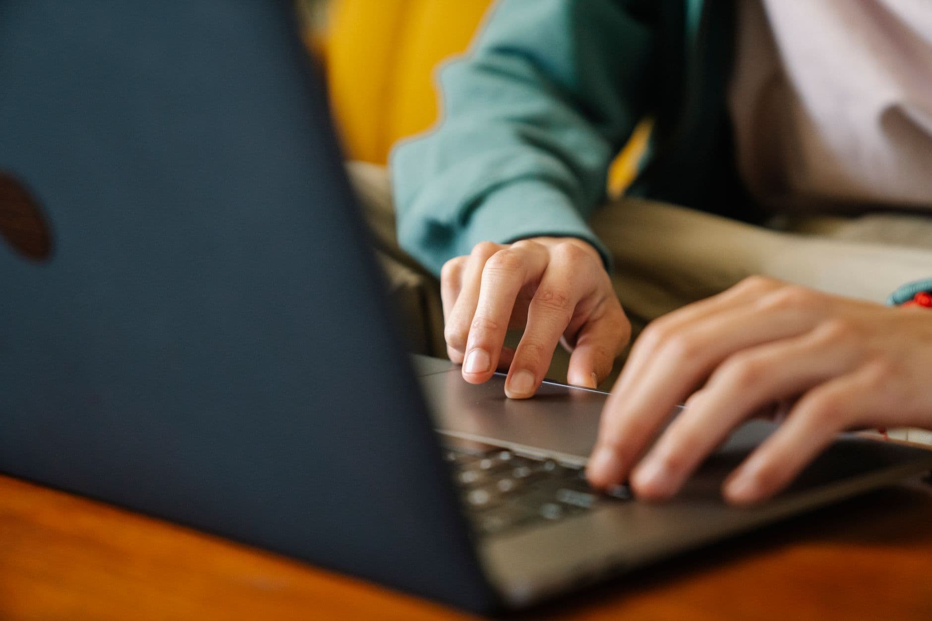 Pessoa pesquisando vagas remotas no LinkedIn em um laptop sobre a mesa de casa.