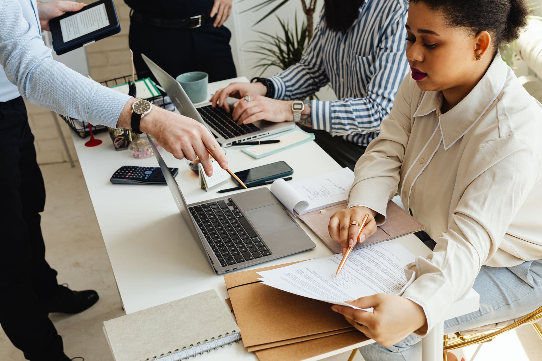 Como usar o Notion no trabalho remoto A diverse team engages in a brainstorming session at a modern, well-equipped workspace.