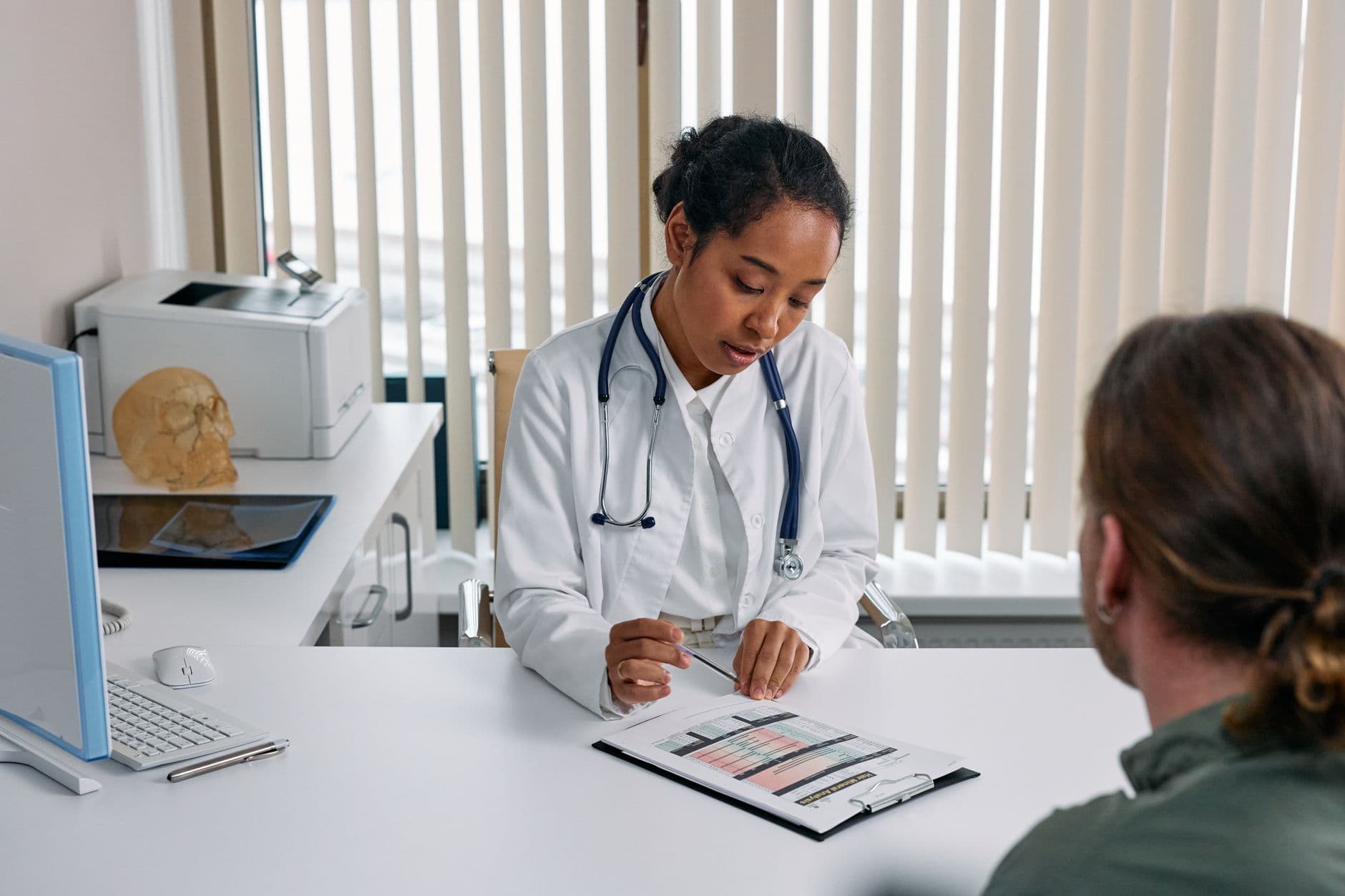 Plano de saúde para autônomo em home office A doctor consulting with a patient in an office, discussing a medical chart.