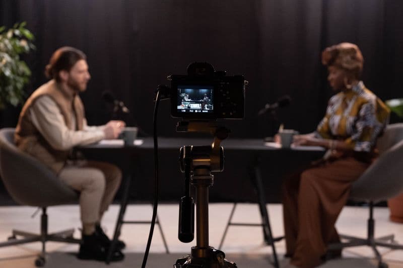 Podcast como ferramenta de carreira remota Two hosts recording a podcast in a studio setting with professional equipment.