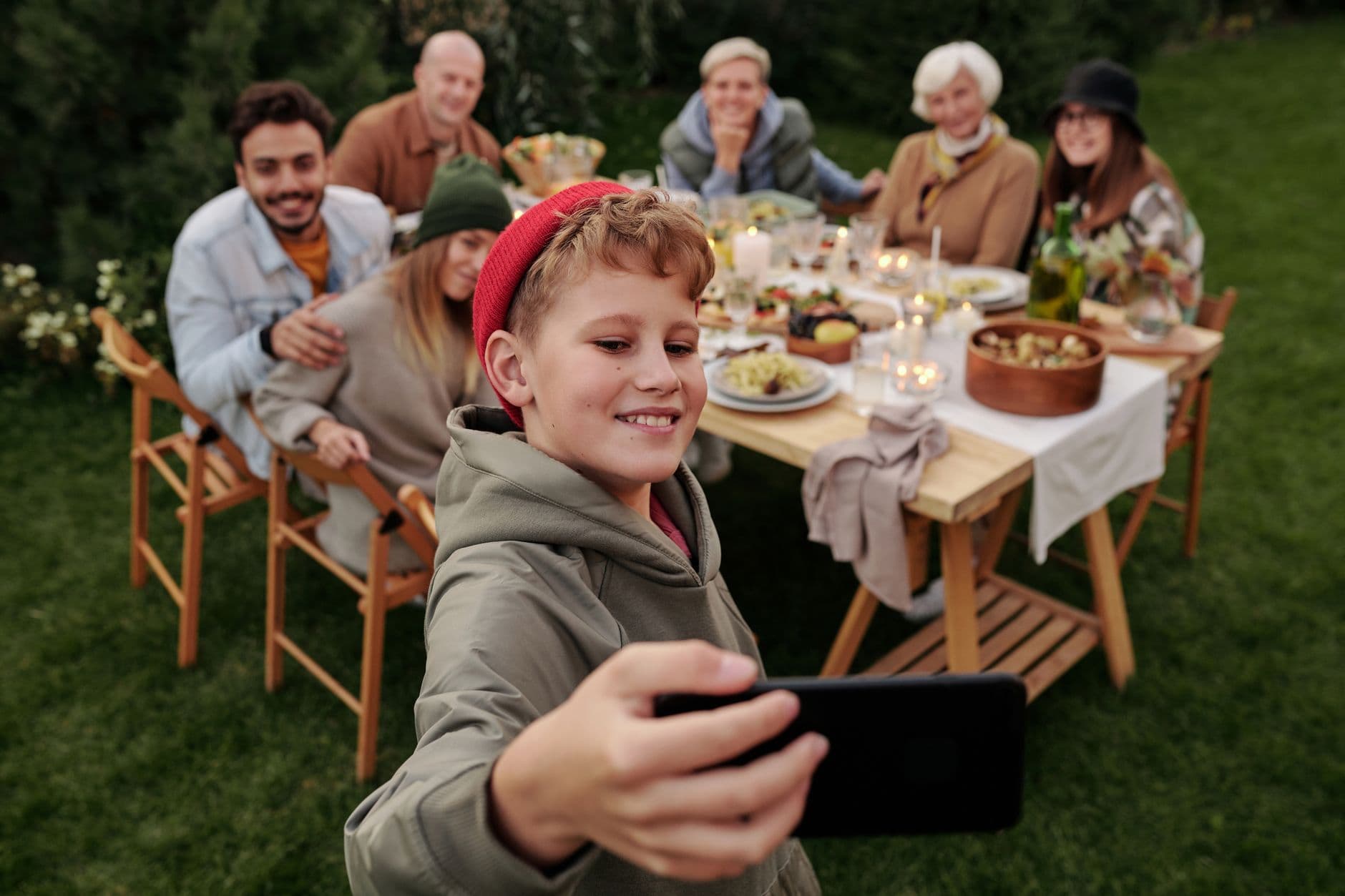 Como separar vida pessoal e trabalho no home office Cheerful family taking a selfie during an outdoor garden dinner party.