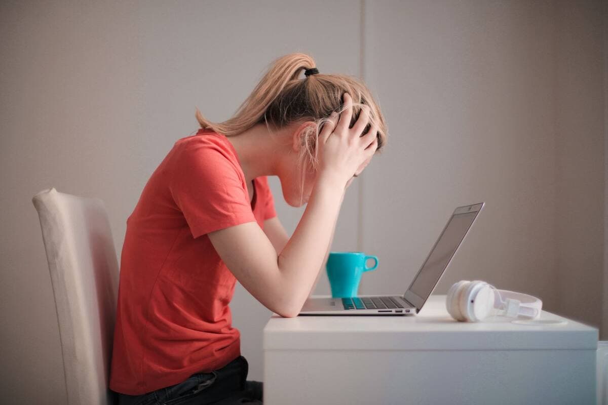 Mulher estressada trabalhando com notebook em casa