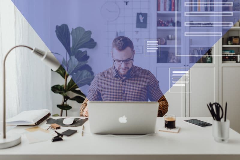 Sobrecarga de mensagens: como lidar no trabalho remoto Man working from home on a laptop with digital overlays in a modern office setting.
