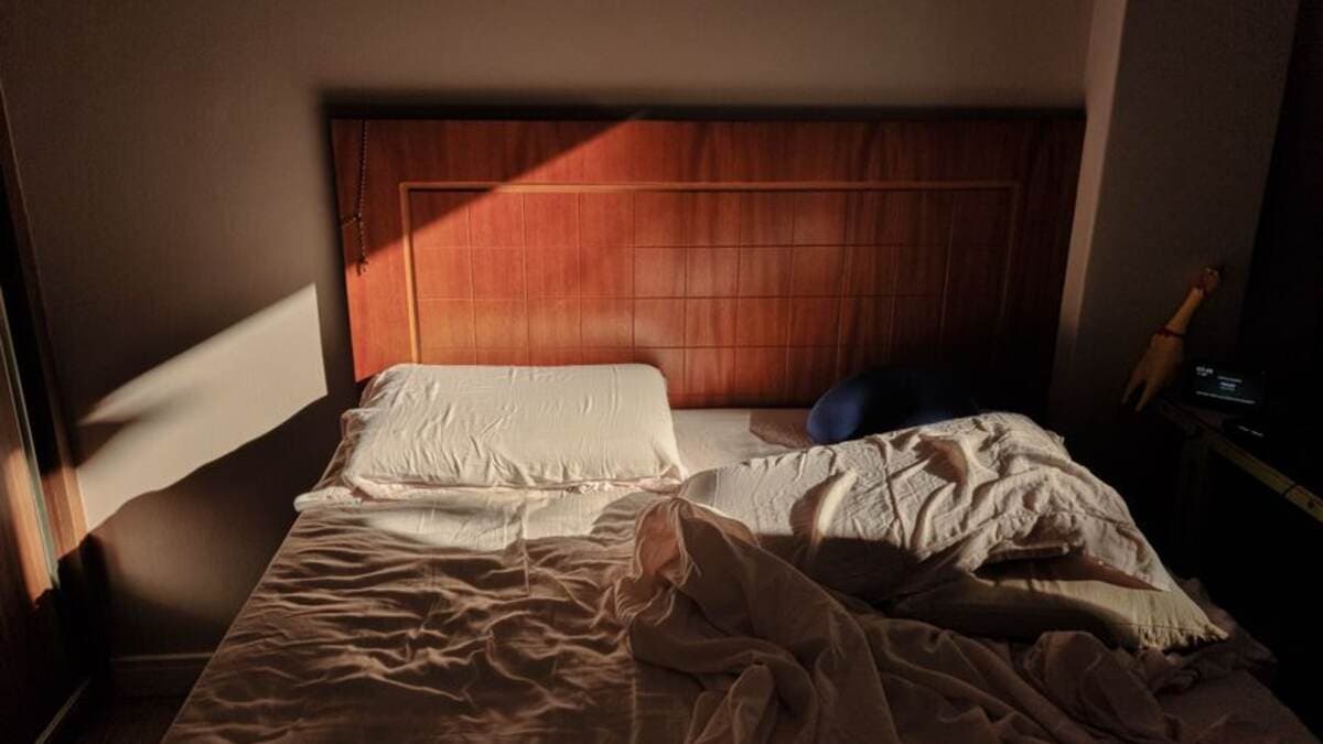 Cama em um quarto com luz suave entrando pela janela