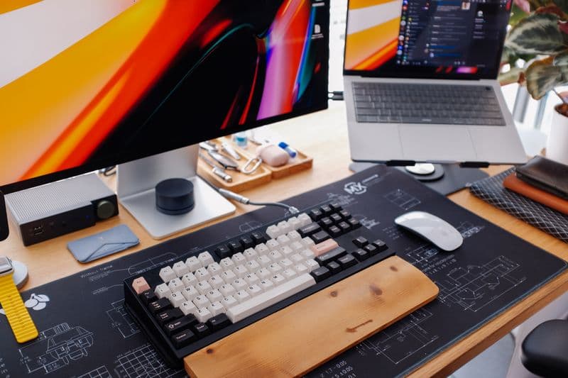 Suporte para notebook vale a pena no home office? A modern workspace featuring a keyboard, monitor, and laptop setup for productivity.