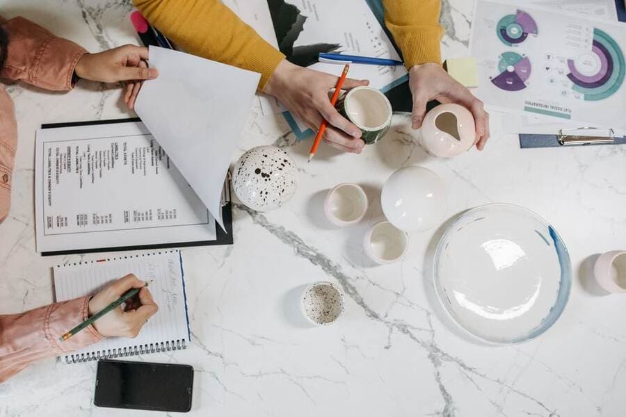 Pessoas planejando tarefas sobre uma mesa com cadernos e anotações Pessoas planejando tarefas sobre uma mesa com cadernos e anotações