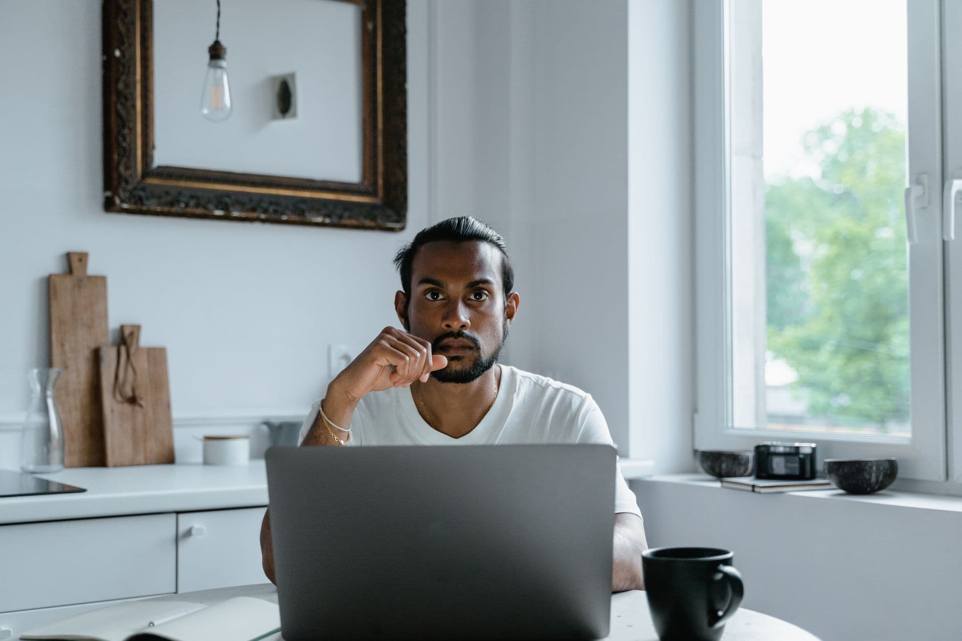 Pessoa trabalhando concentrada em um notebook com cronômetro sobre a mesa do home office.