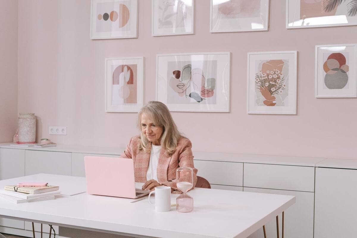 Mulher de mais de 50 anos trabalhando no notebook em escritório moderno