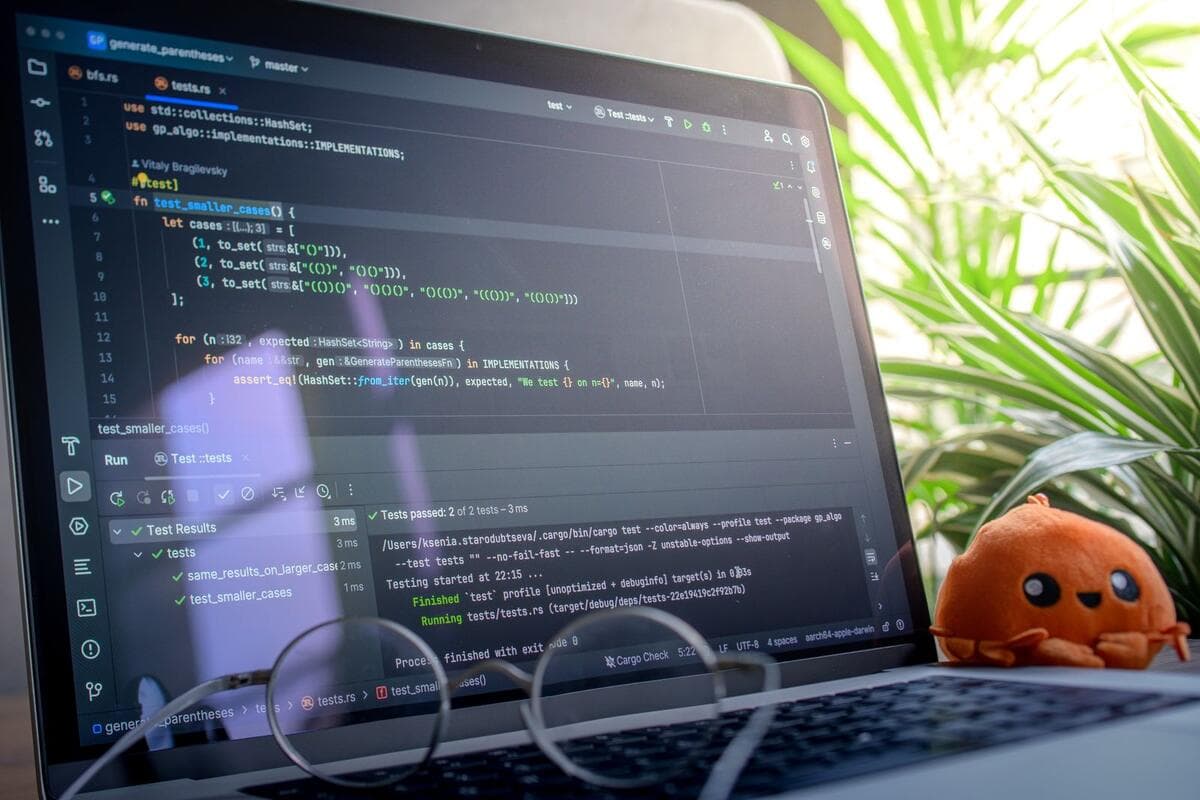 Notebook aberto exibindo código em uma mesa com plantas