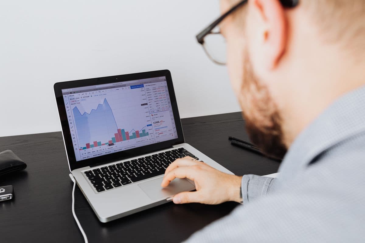 Profissional trabalhando remotamente em laptop enquanto analisa informações de uma startup