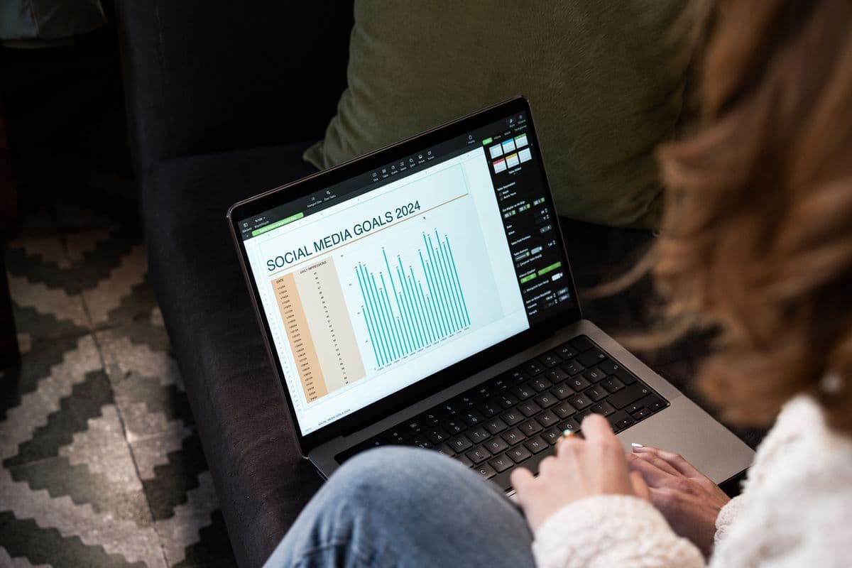 Profissional analisando uma campanha de marketing digital em um notebook no home office.