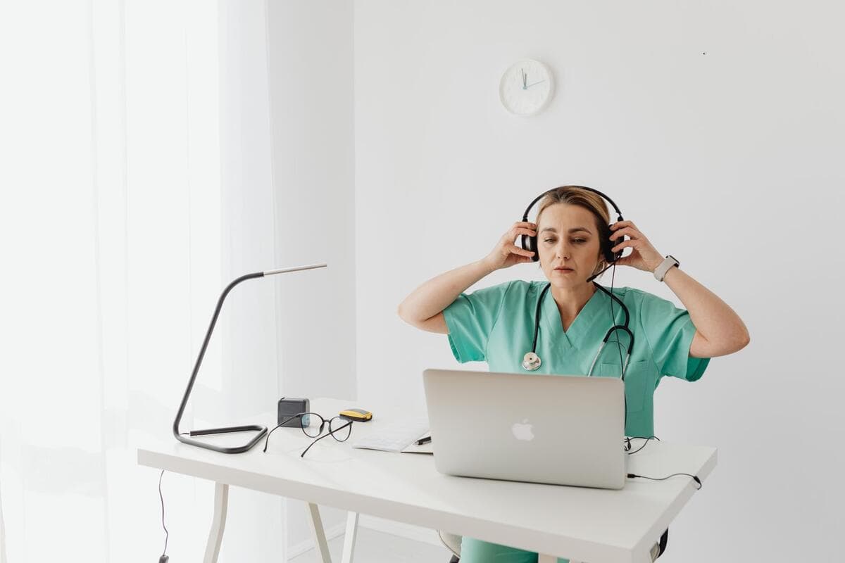 Funções remotas que não exigem atender pacientes Profissional de saúde de fone de ouvido trabalhando no notebook em uma mesa