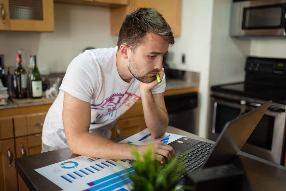 Profissional analisando dados de logística em um notebook no escritório de casa