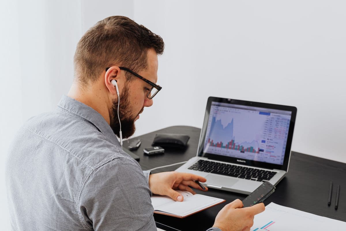Profissional analisando planilhas financeiras em um notebook no home office