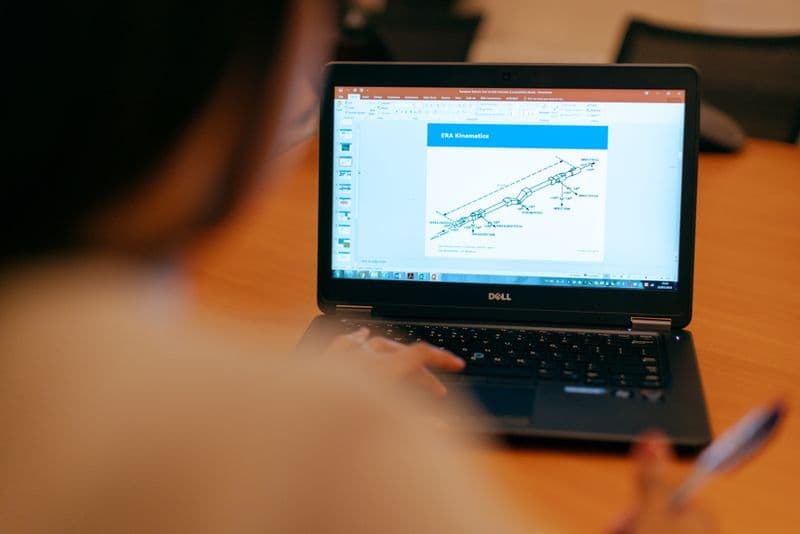 Vagas remotas para engenheiros: onde procurar Female engineer working on laptop reviewing technical engineering presentation.