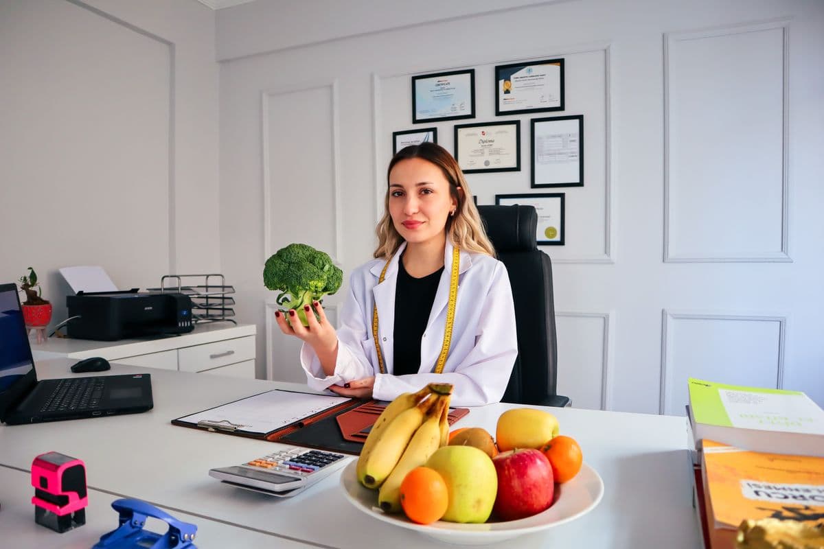 Nutricionista atende paciente por videochamada em um home office organizado.