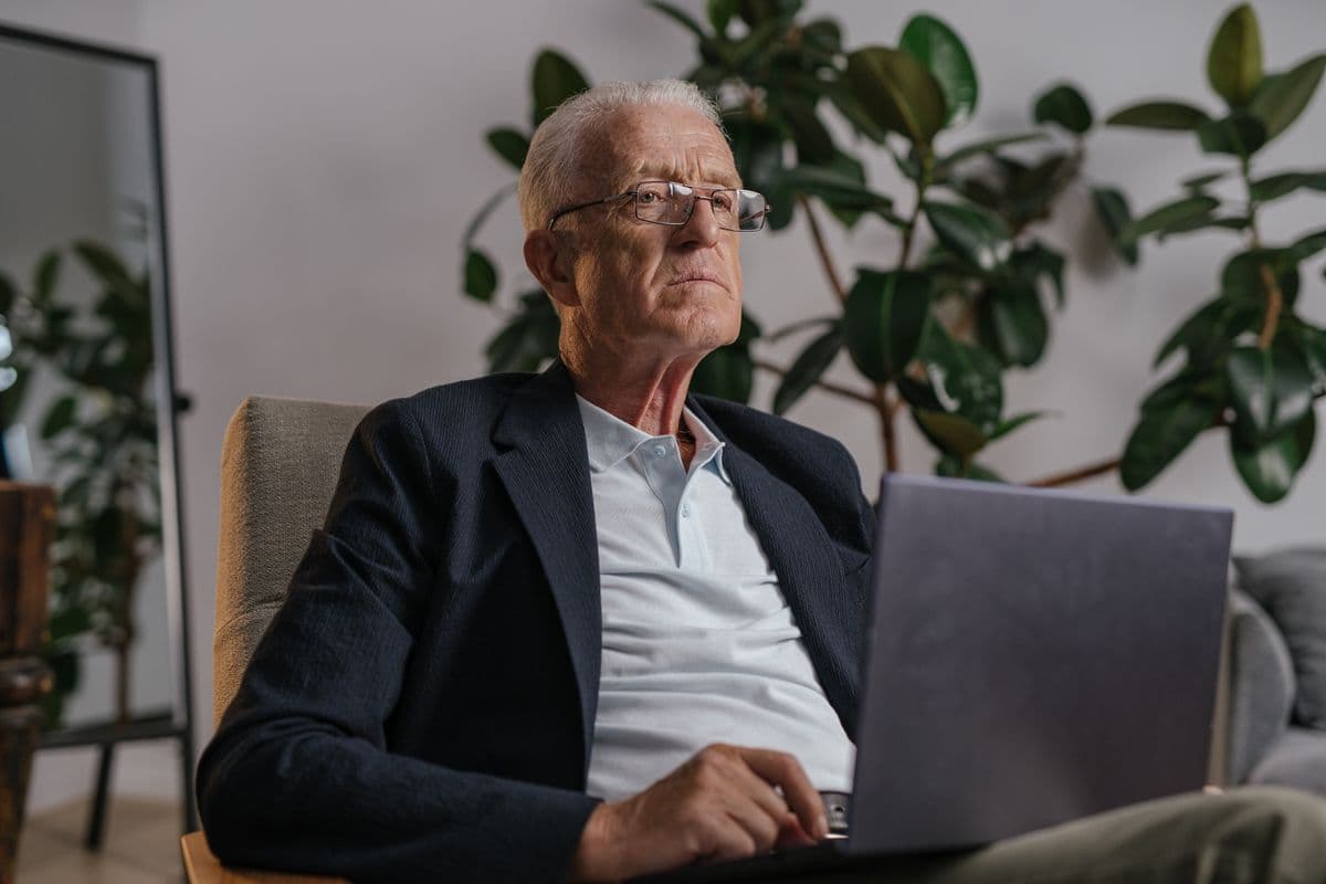 Profissional experiente trabalhando em um laptop em um escritório doméstico organizado