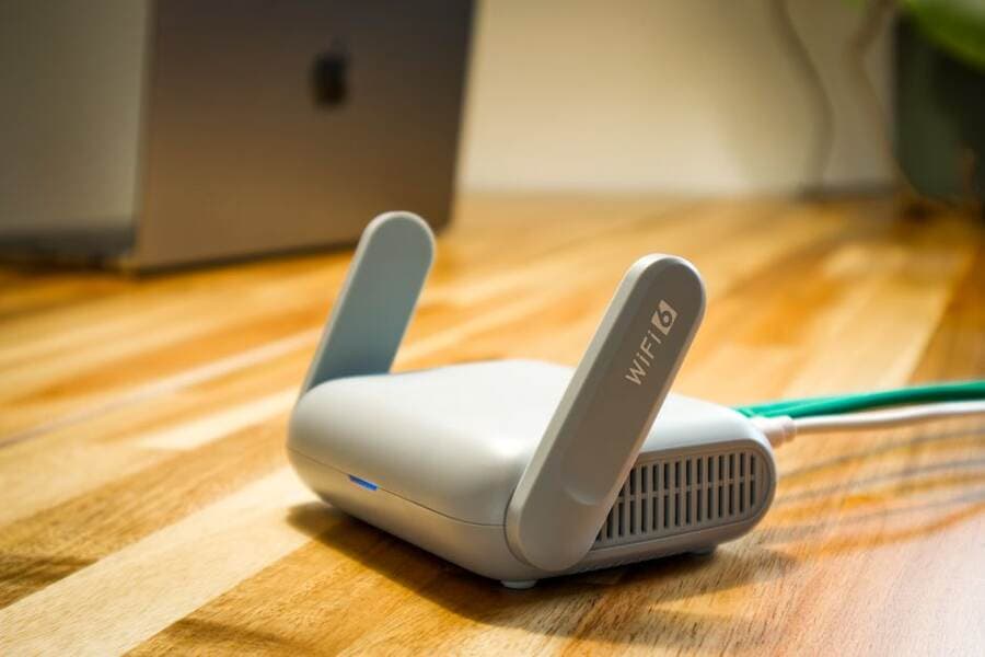 Roteador Wi-Fi compacto sobre uma mesa de madeira Roteador Wi-Fi compacto sobre uma mesa de madeira